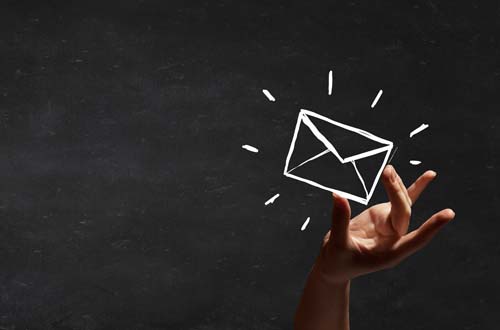 Person hand taking chalk drawn email sign